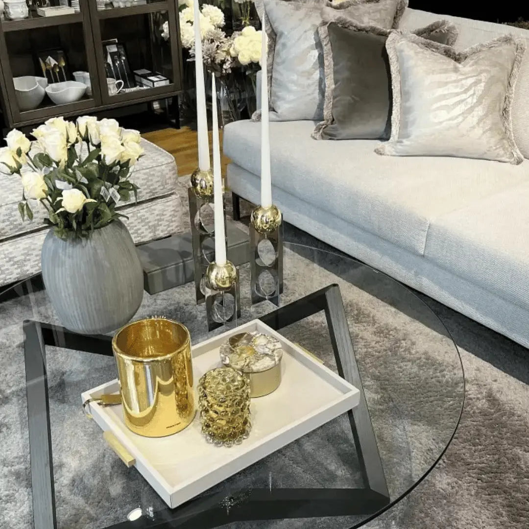 Glassbord innredet med marmorbrett, blomstervase og lysestaker i utstillingsrommet til Lene Interiør